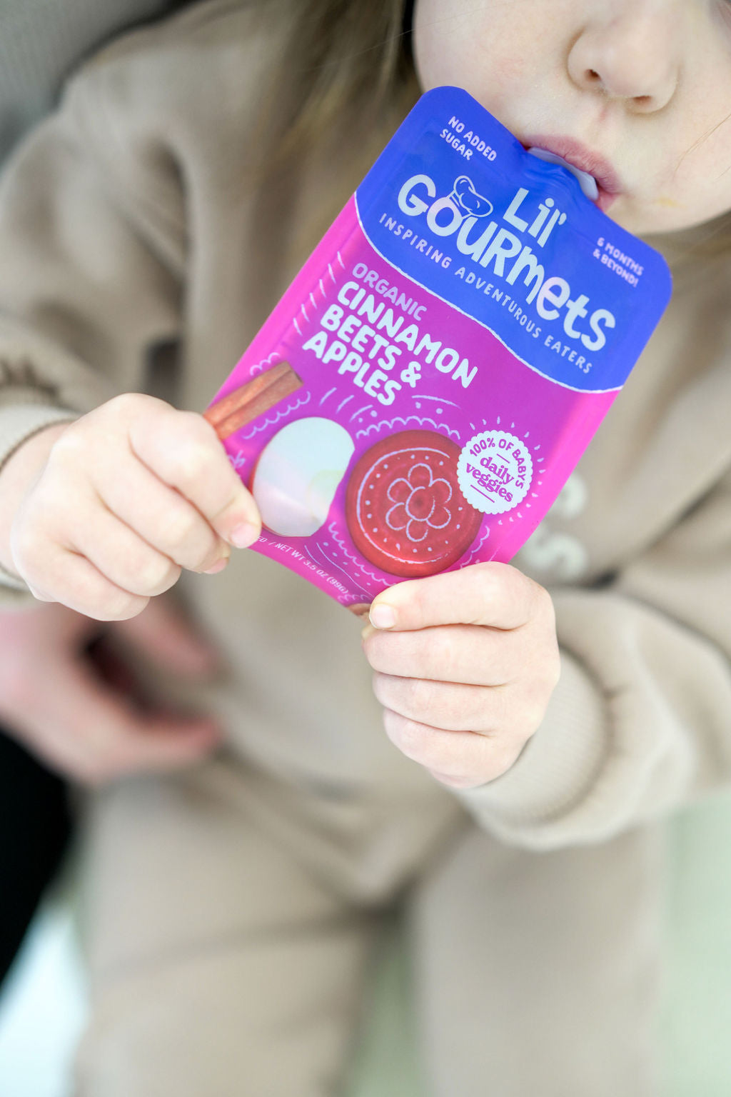 Little girl enjoying a pouch of Lil' Gourmets Cinnamon Beets & Apples